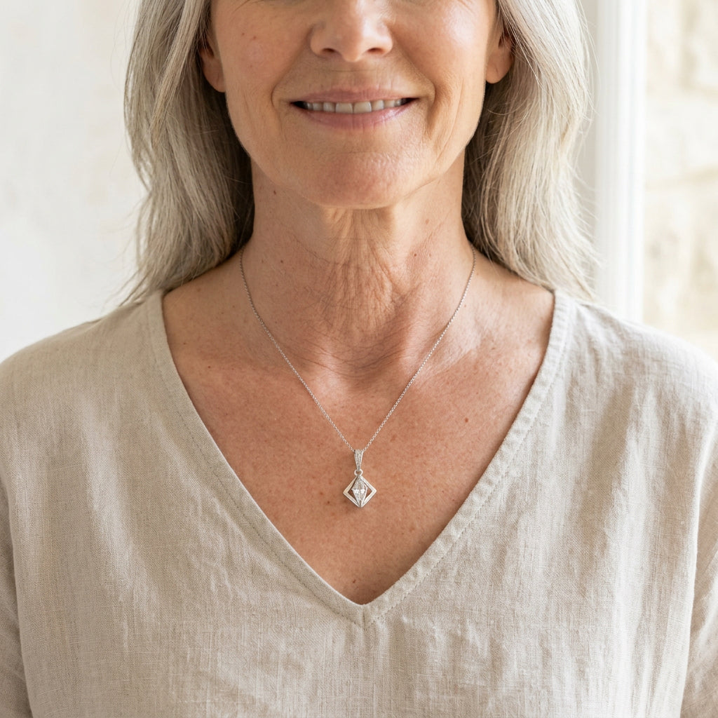 Silver Floating Prism pendant worn at the collarbone, clear faceted glass bead catching the light