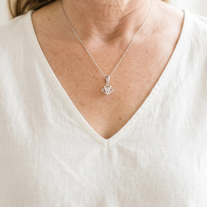 Woman wearing a silver Floating Prism necklace with a clear faceted glass bead suspended in an open 3D frame