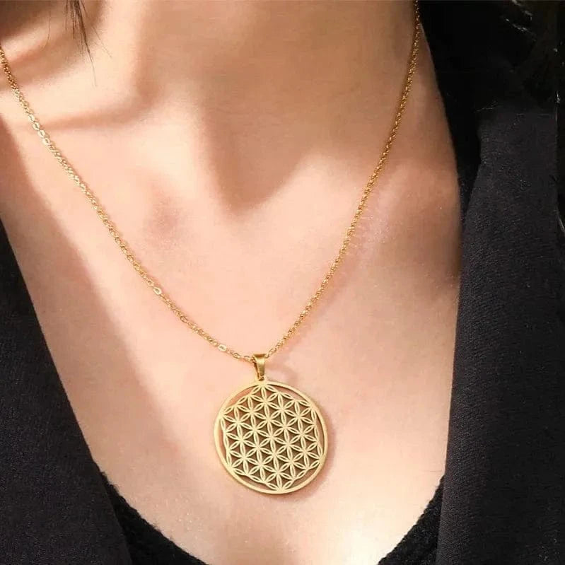 Gold necklace with a circular pendant worn by a person against a black background