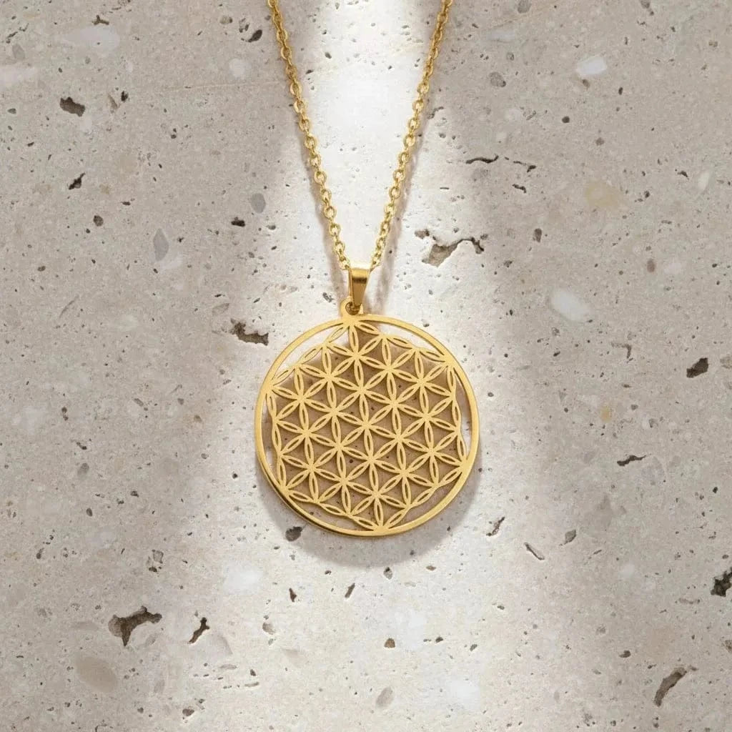 Gold necklace with a geometric pendant on a black background, branded 'Unift'.