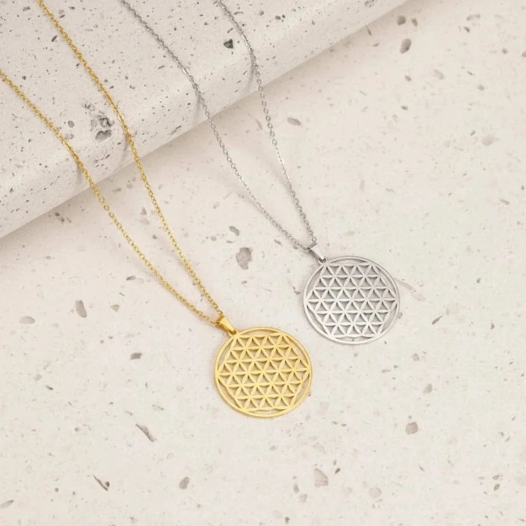 Two geometric pendants on chains against a teal background