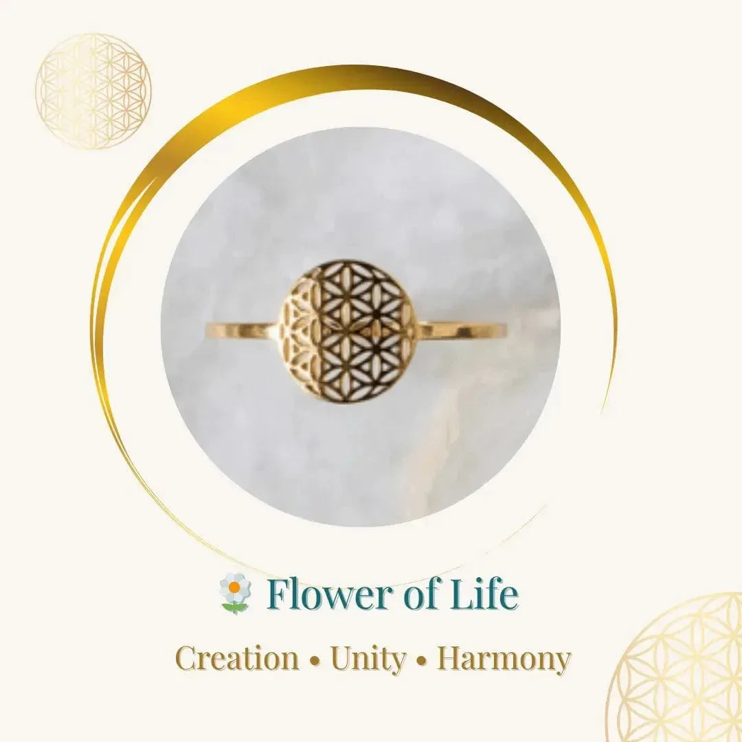 Gold ring with Flower of Life design on a marble surface, surrounded by geometric patterns.