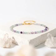 Multicolored beaded bracelet on a white surface with crystal decorations