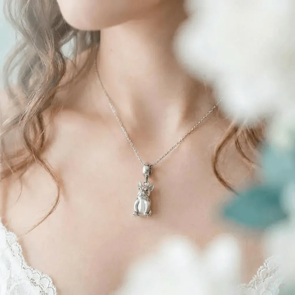 Silver necklace with a pendant worn by a person, blurred background