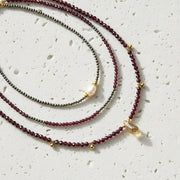 Three beaded necklaces with gold accents on a white background