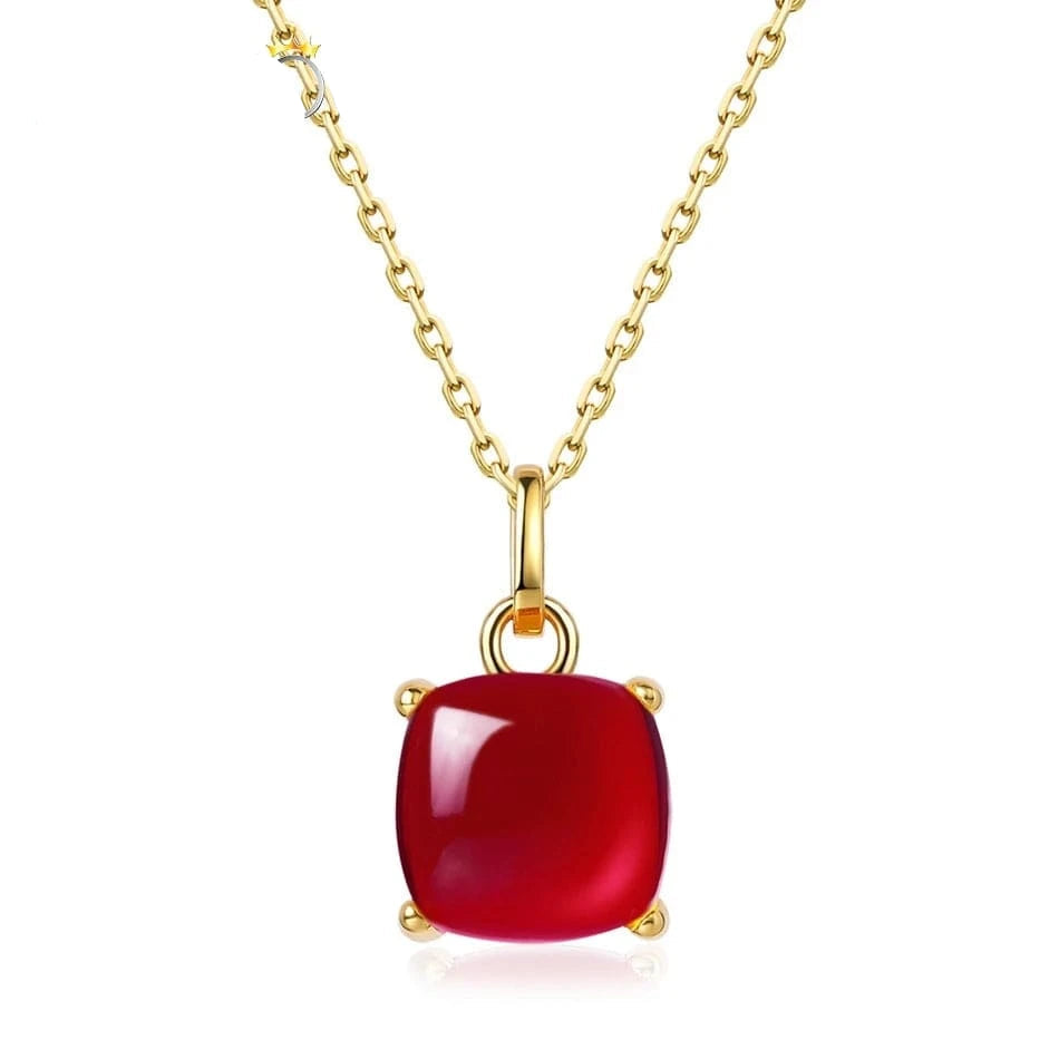Gold necklace with a red pendant on a white background
