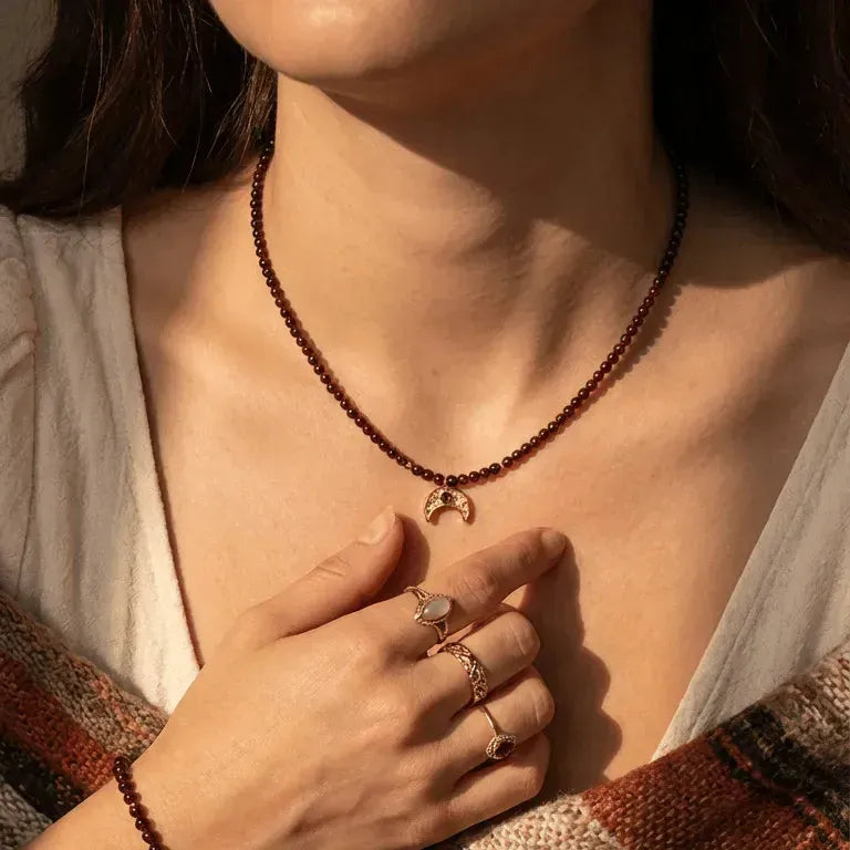 Person wearing a beaded necklace with crystals and a notebook on a textured surface, with 'Mystic Soul Jewelry' text.