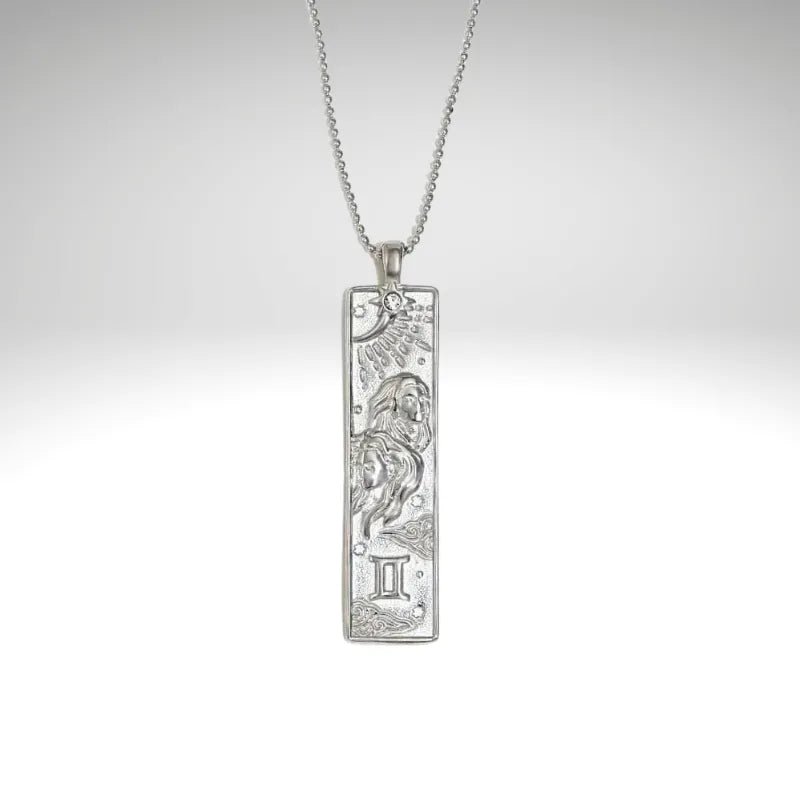 Silver zodiac pendant with chain on a light gray background