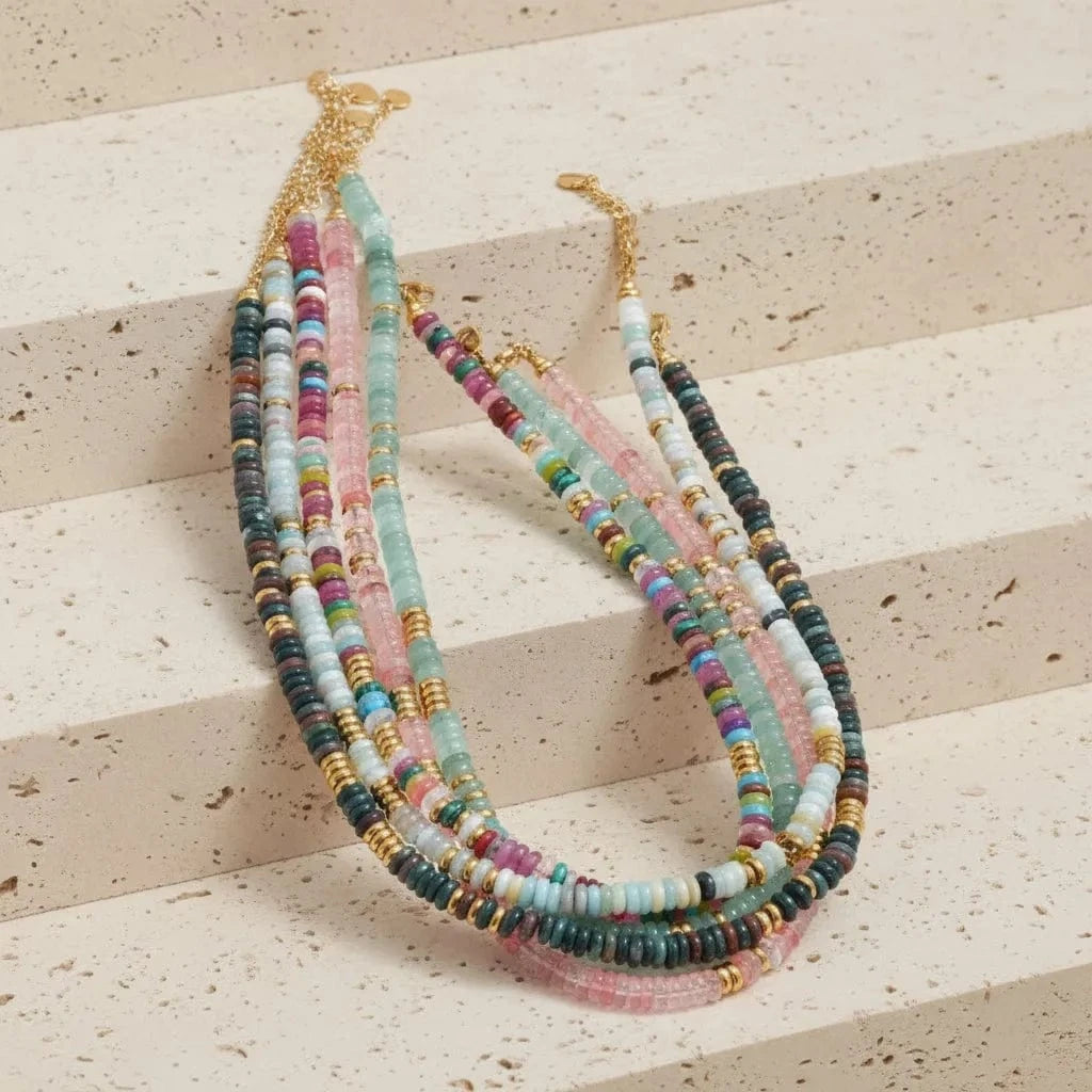 Multicolored beaded necklace with gold accents on a white background