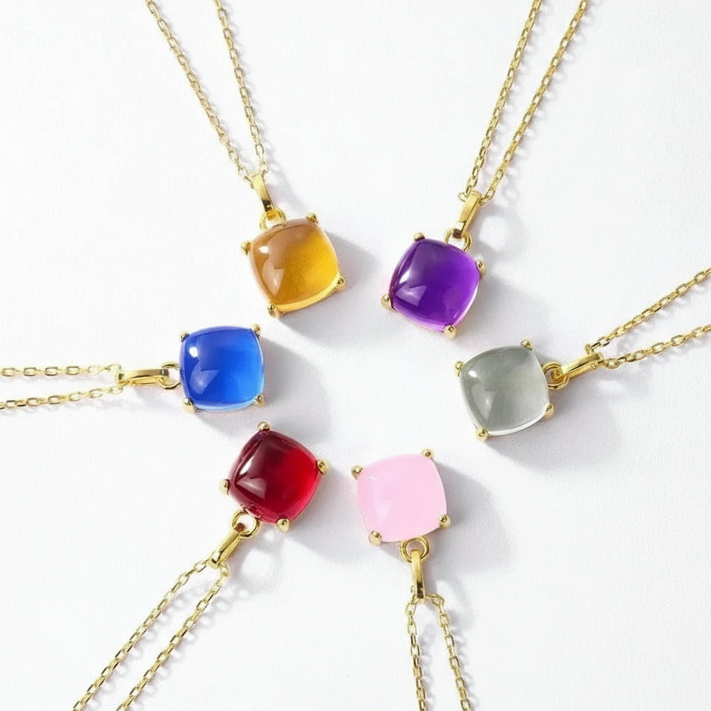 Colorful gemstone necklaces with gold chains on a white background