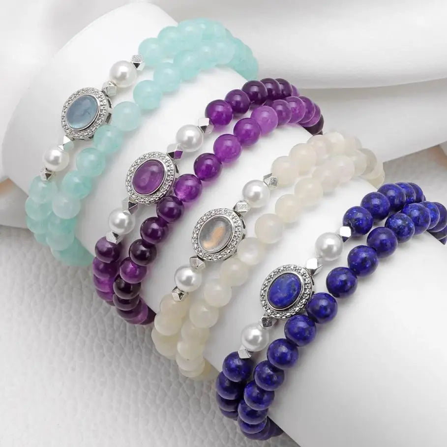 Set of beaded bracelets in purple, white, and blue on a white surface