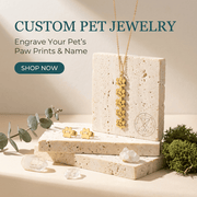 Custom pet jewelry set with necklace and earrings on a stone block, surrounded by greenery.