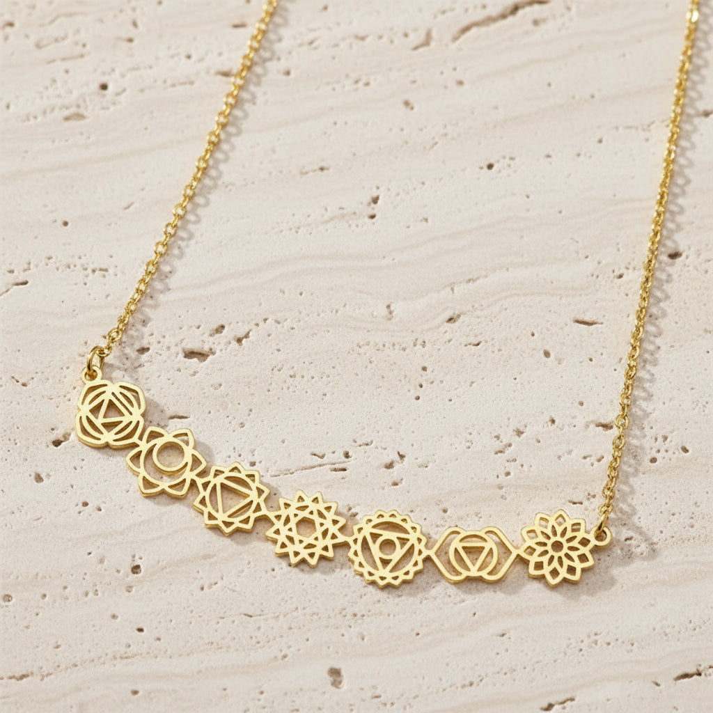 Gold necklace with geometric floral designs on a dark surface