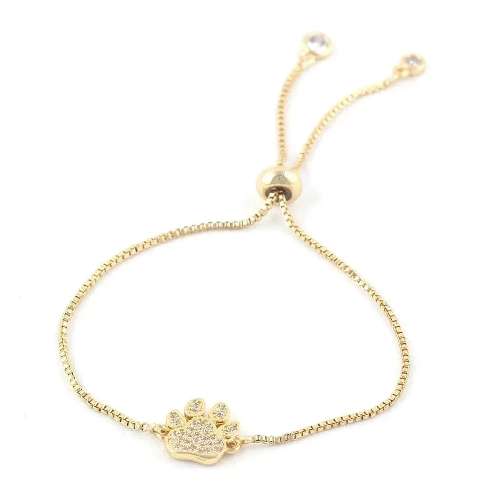 Gold bracelet with paw charm on a white background