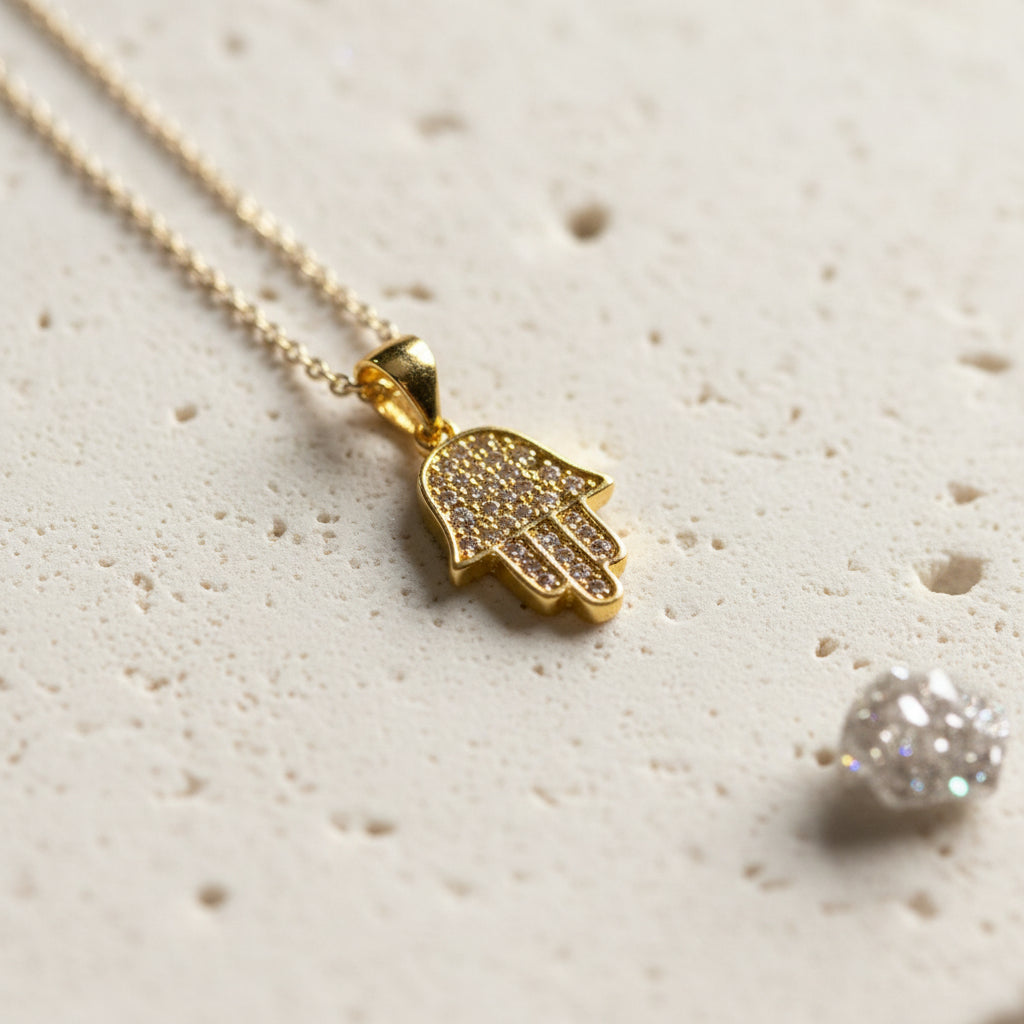 Close-up of a gold crystal hamsa pendant on a fine chain