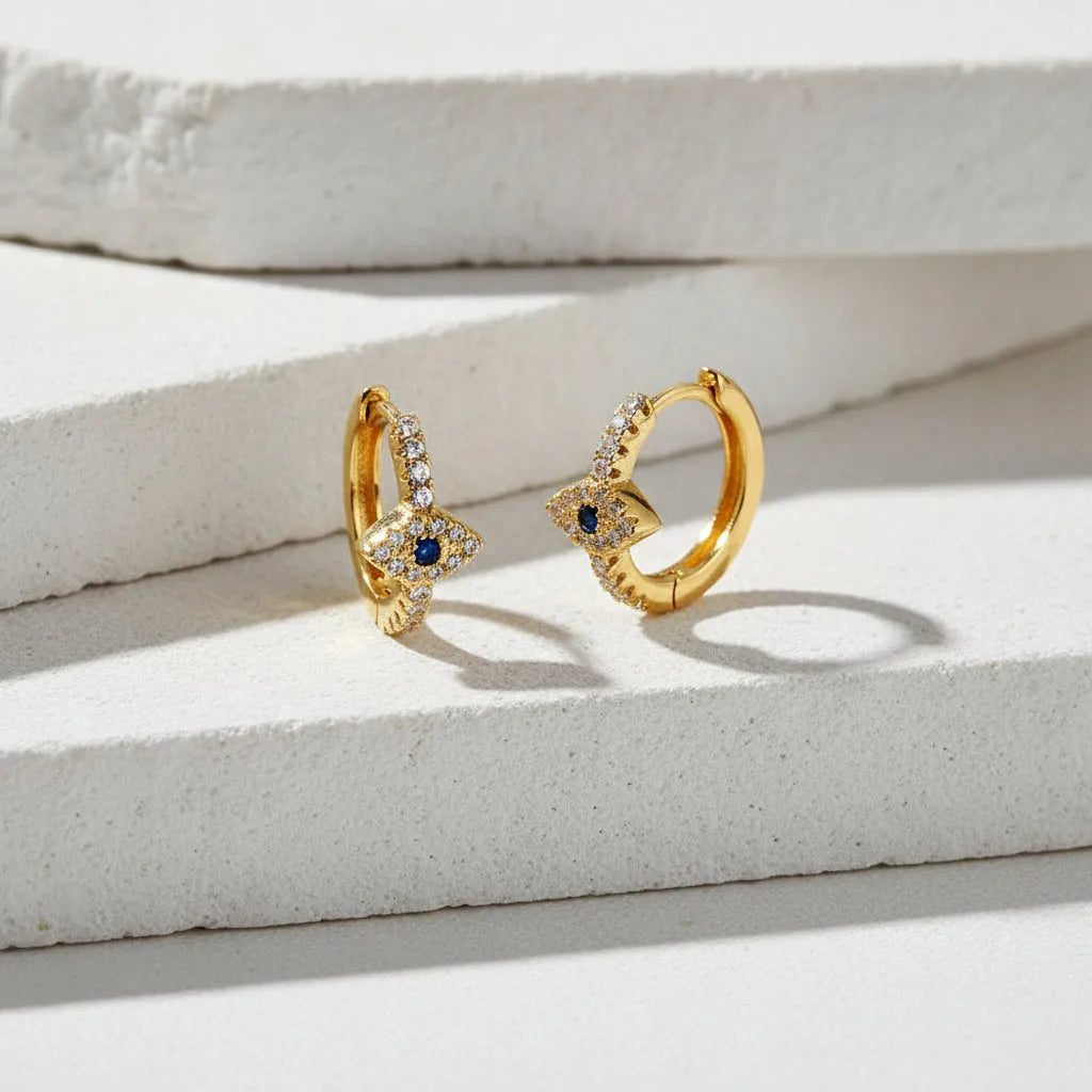 Gold hoop earrings with gemstones on a white backgroun 