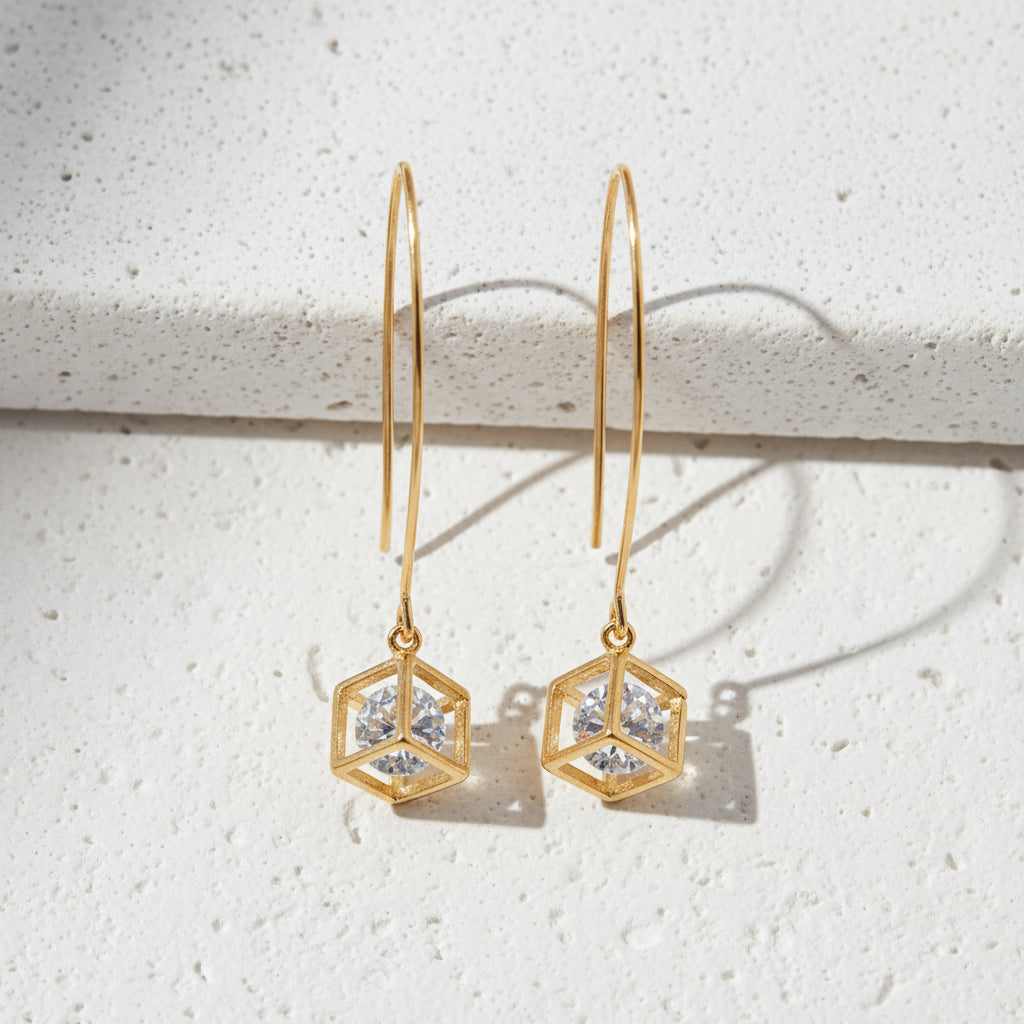 Gold geometric earrings on a white background