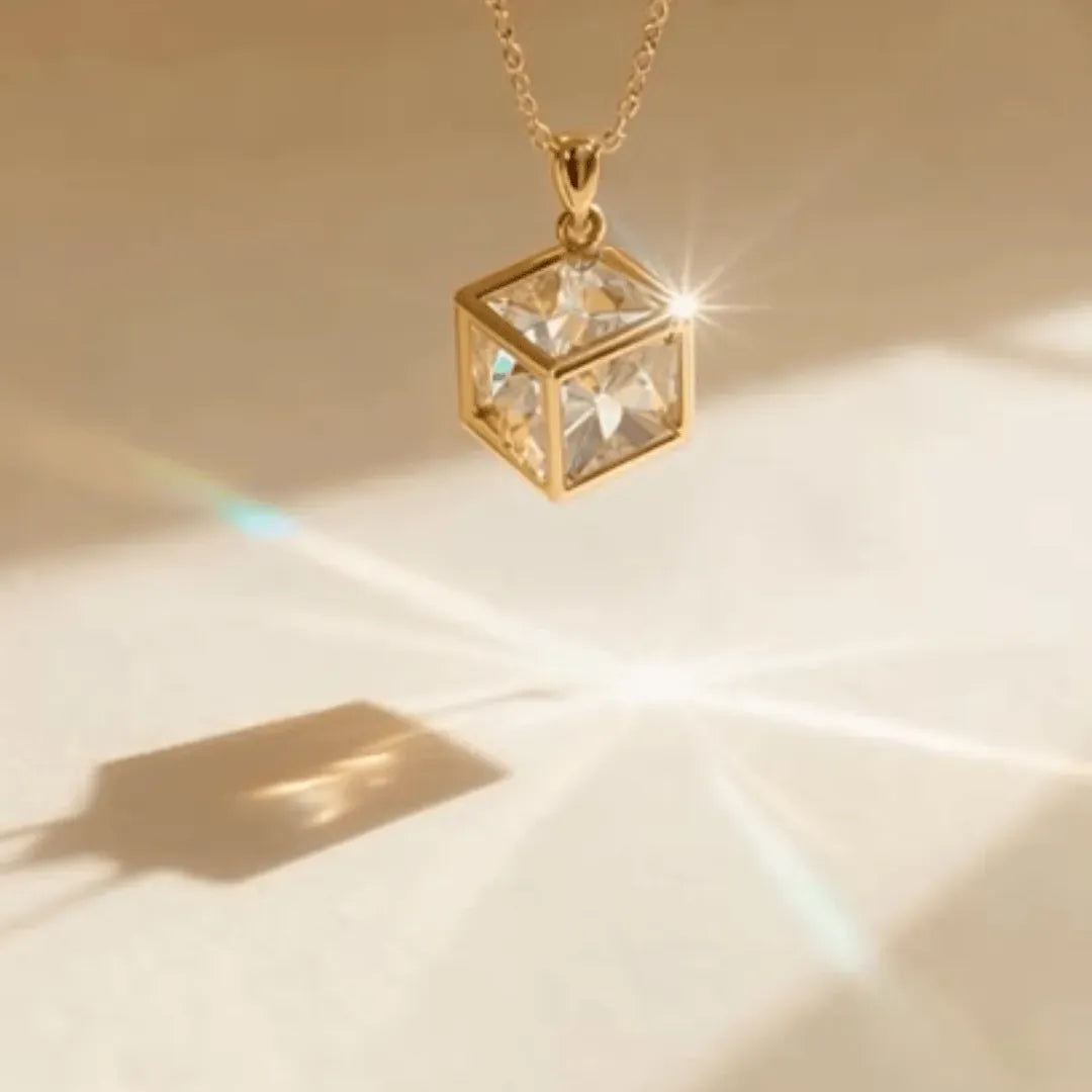 Gold cube pendant necklace on a beige background
