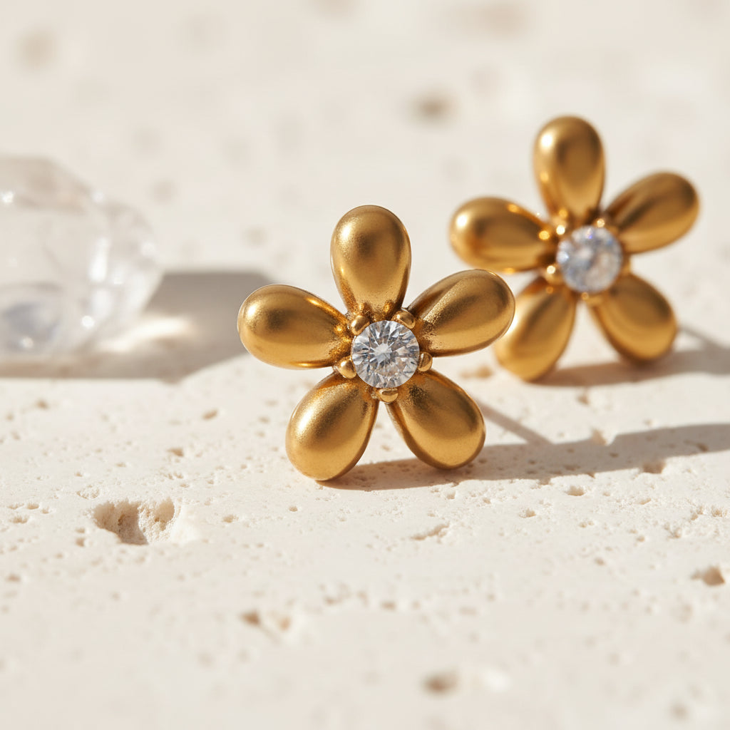 Close-up of gold flower stud earrings with cubic zirconia centre