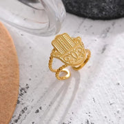 Gold ring with intricate design on a textured surface