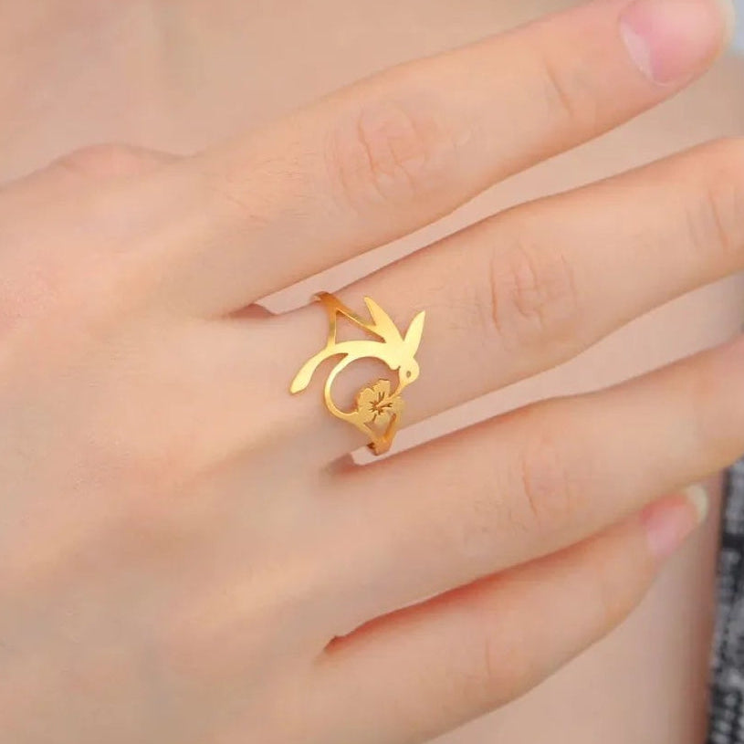 Gold hummingbird flower ring worn on the hand — spirit animal jewelry for joy