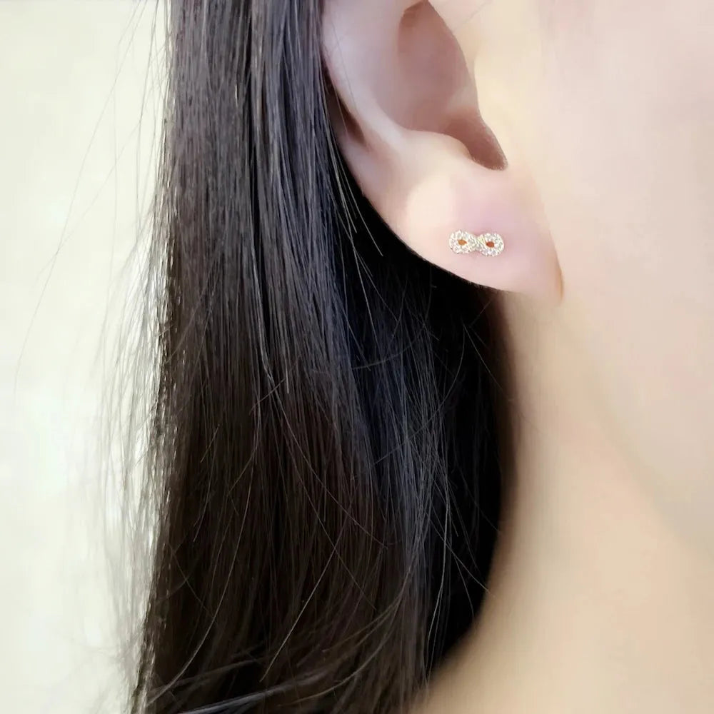 Close-up of an ear wearing a small stud earring with a blurred background