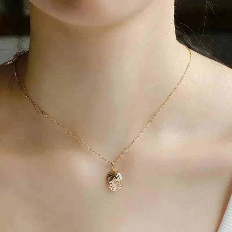 Gold necklace with a pendant on a person's neck