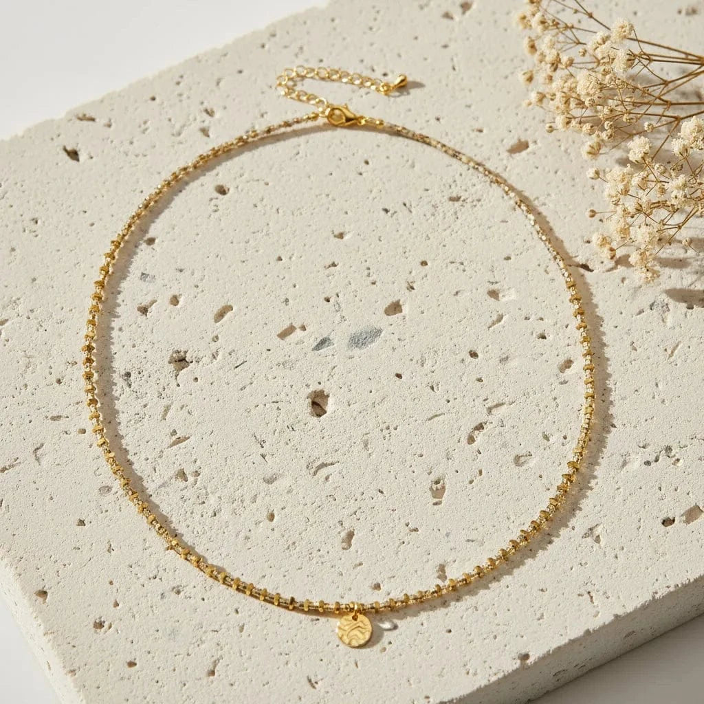 Gold necklace with a heart pendant on a white background