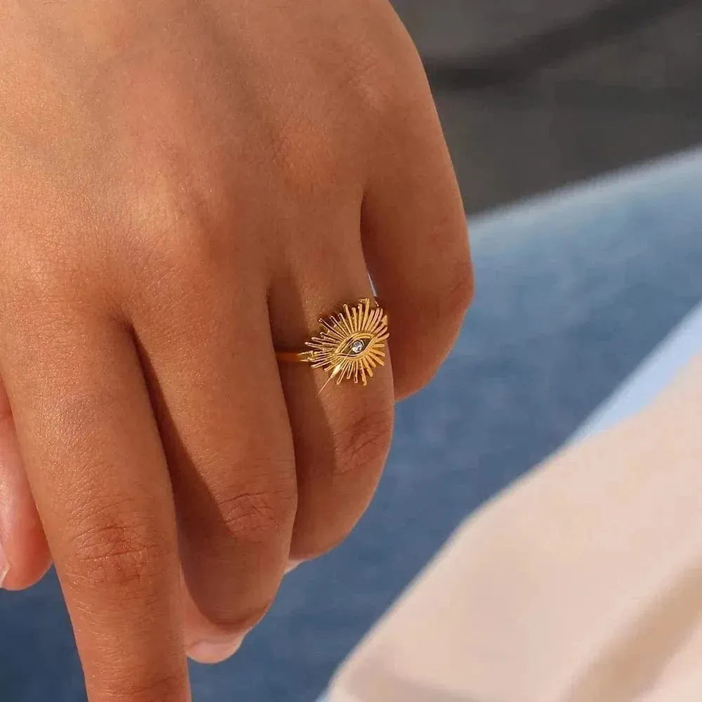 Gold ring with a diamond on a person's finger against a blurred background