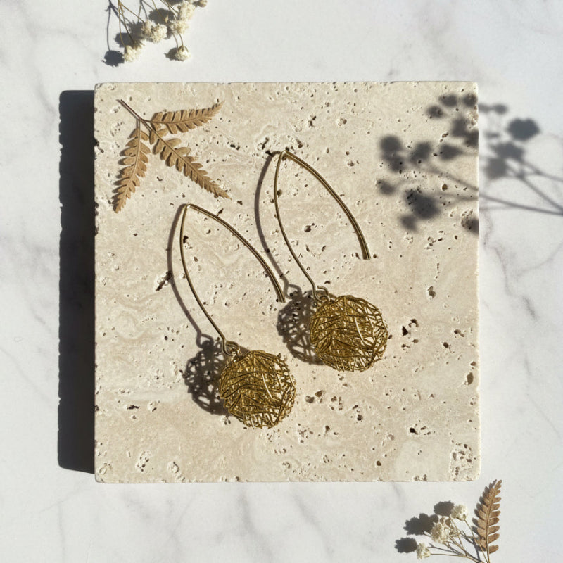 Gold plated circle Global Connection long drop earrings flat lay, sacred geometry jewelry