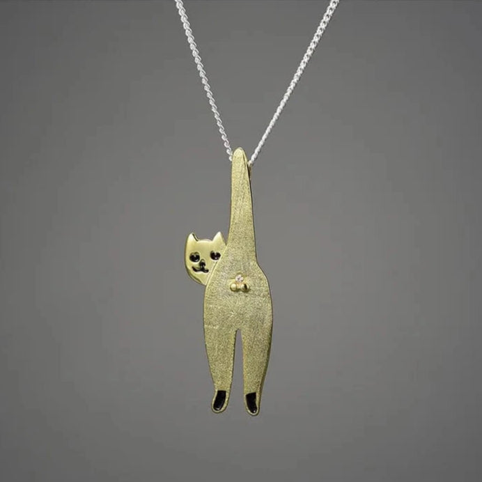 Gold cat-shaped pendant on a gray background