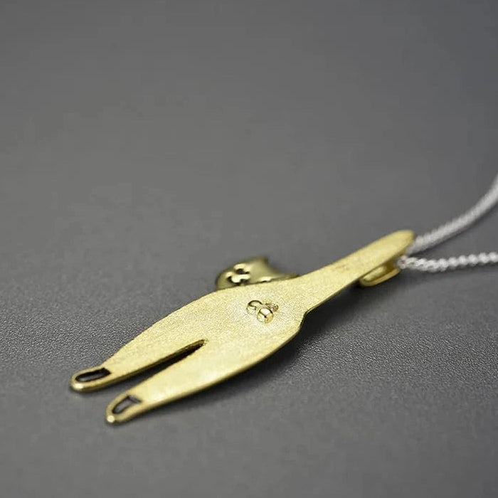 Gold necklace pendant on a gray background