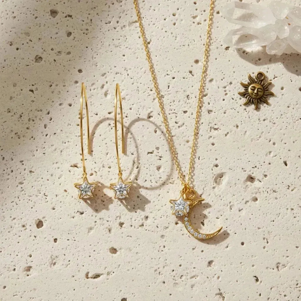 Gold star earrings and crescent moon necklace on a white background