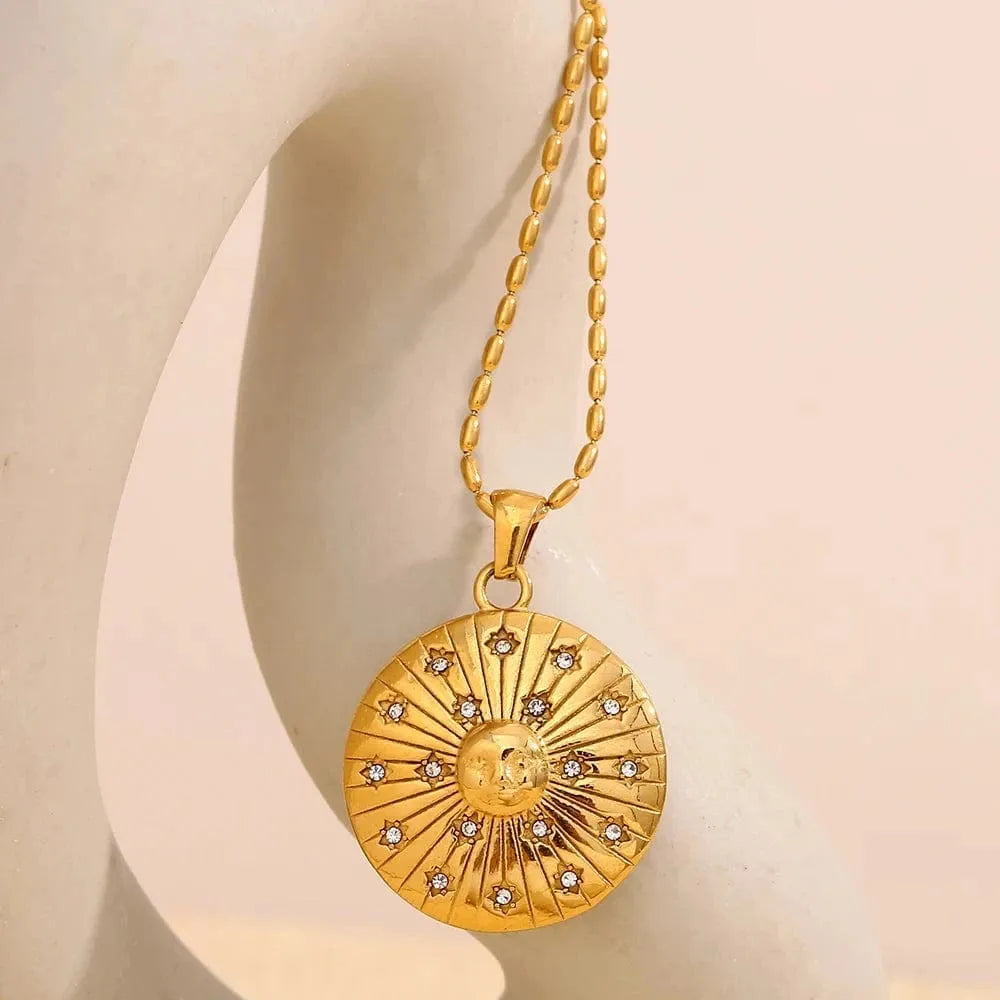 Gold necklace with a circular pendant on a beige background