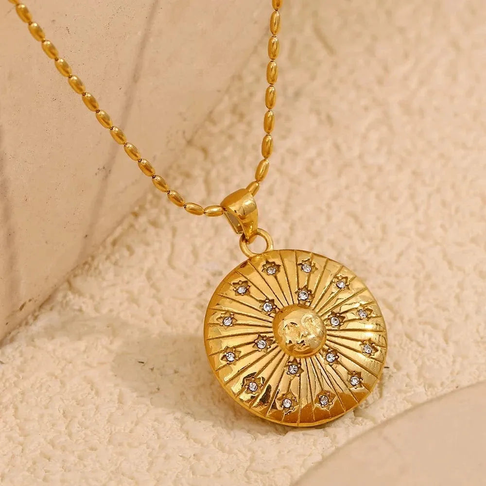Gold necklace with a round pendant on a beige background