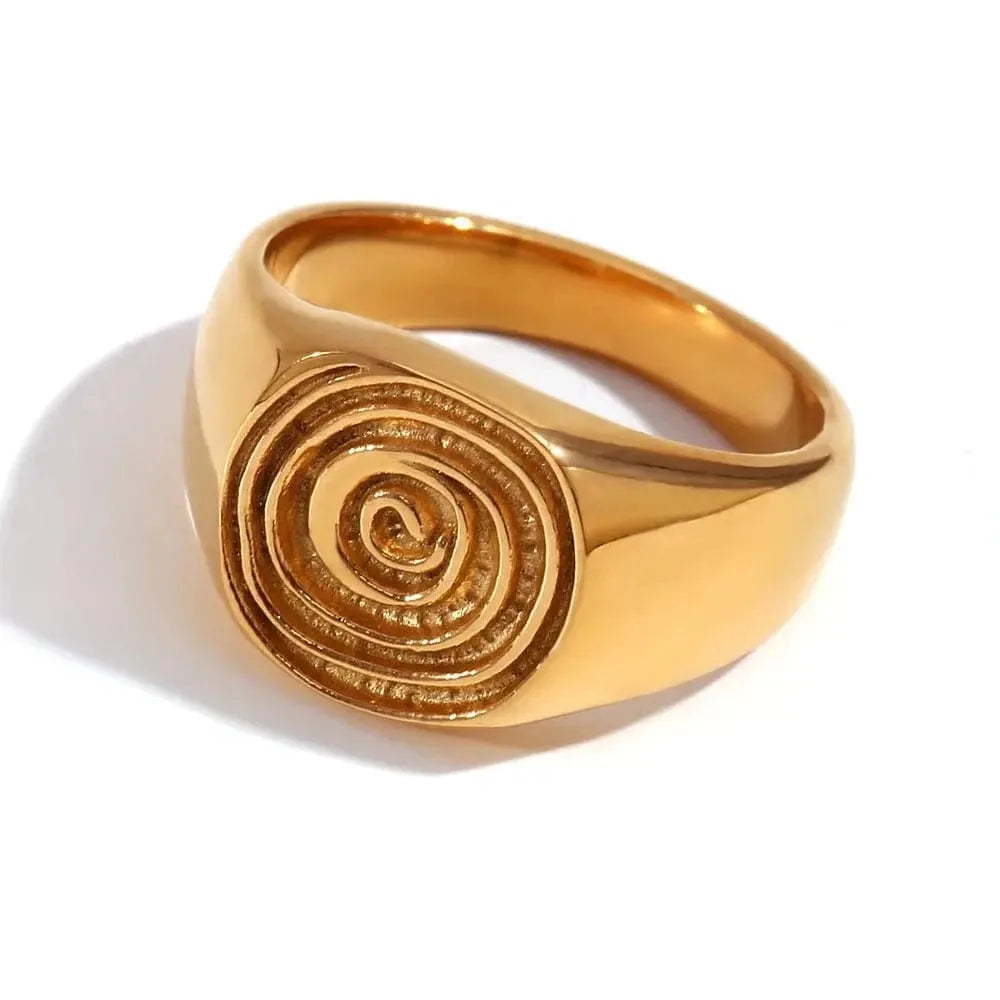 Gold ring with spiral design on a white background