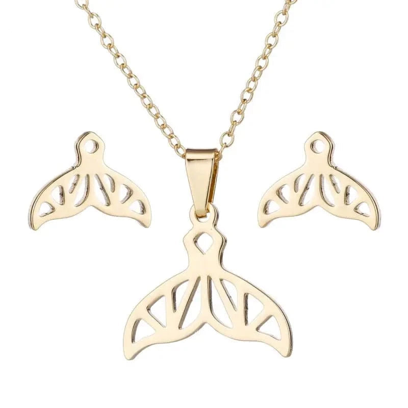 Gold whale tail necklace and earrings set on a white background