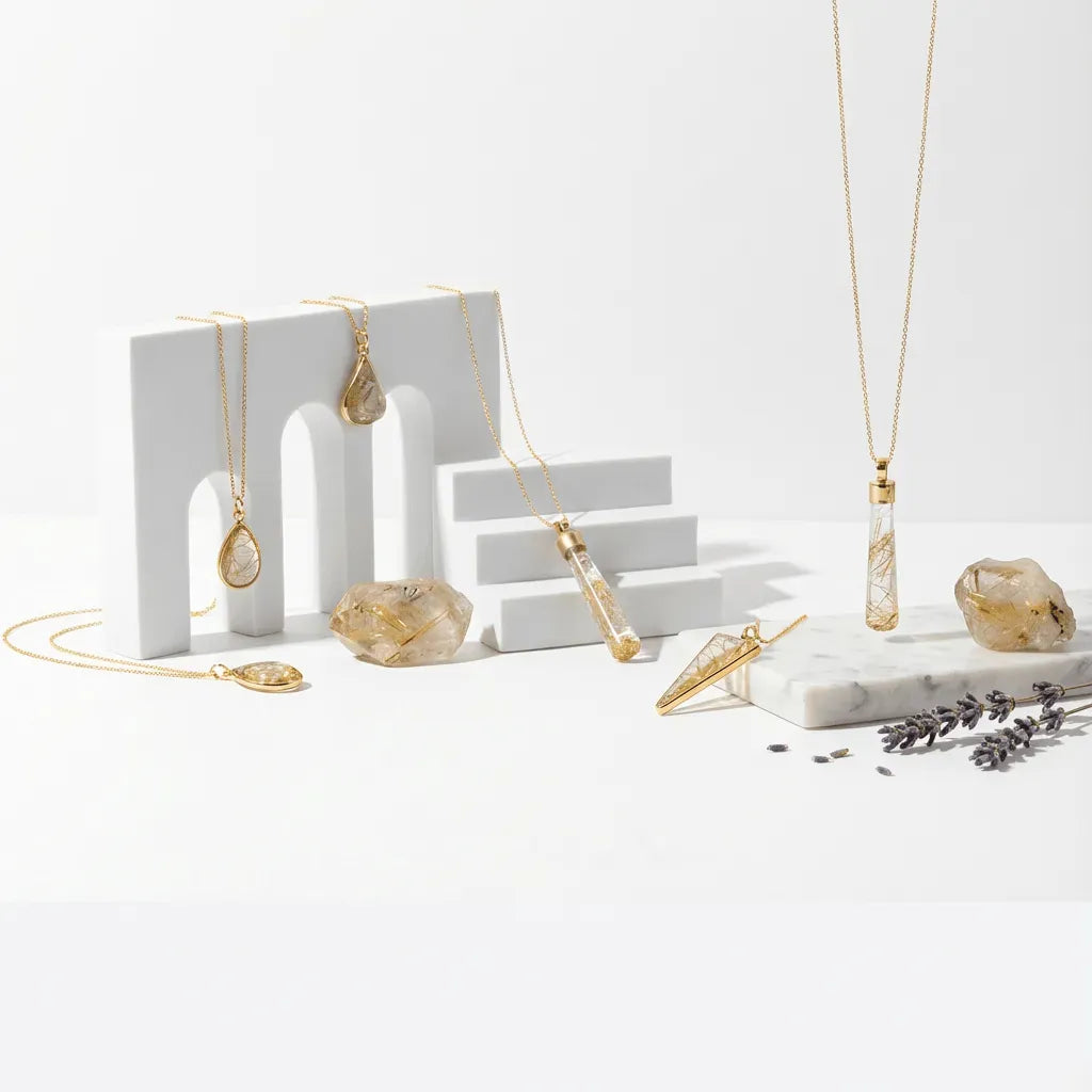 Gold necklaces on a white surface with decorative stones and lavender.