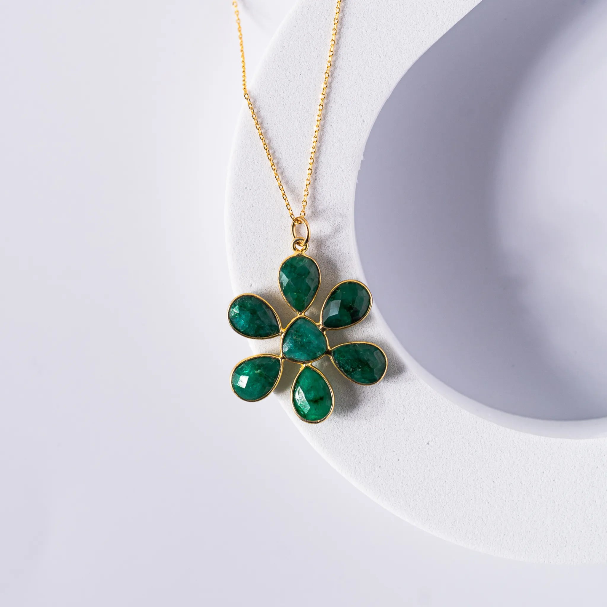 Gold-plated flower pendant necklace featuring an opaque emerald stone