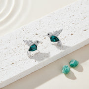 Woman wearing teal crystal hummingbird stud earrings in sterling silver — spirit animal jewelry for joy