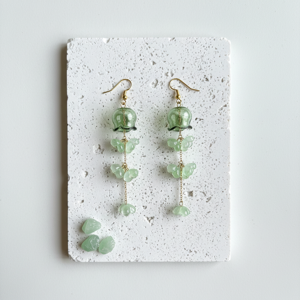 Green glass jellyfish earrings with gold cascading florets on shepherd's hook wires