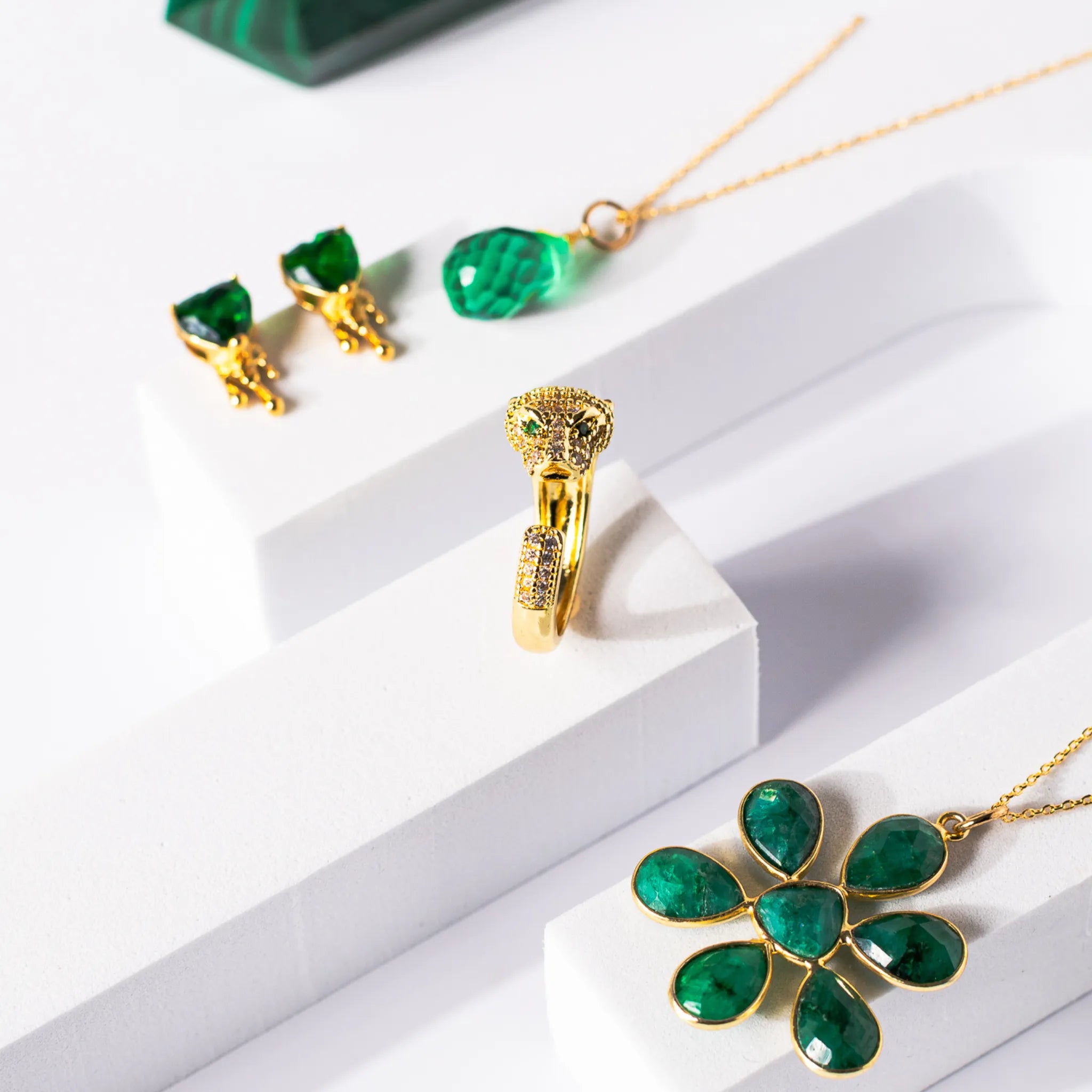 Gold-plated flower pendant necklace featuring an opaque emerald stone