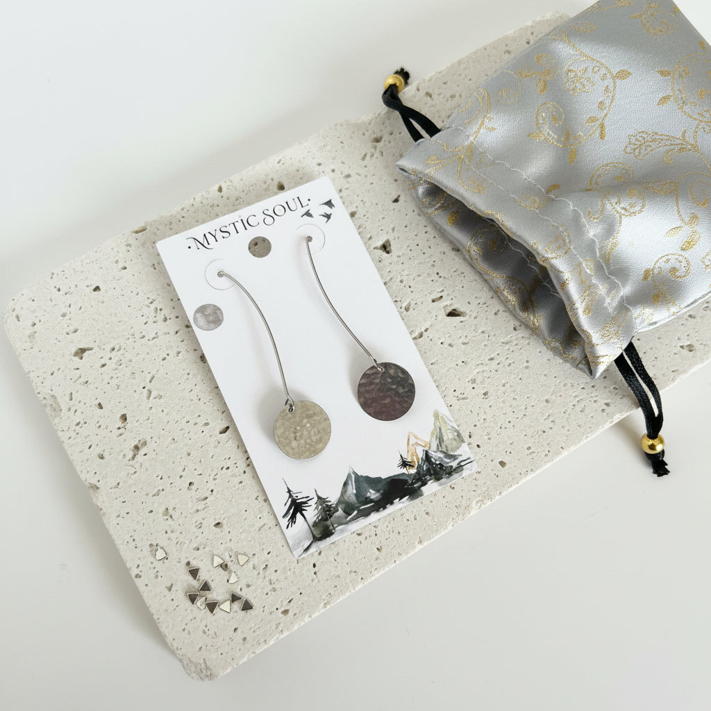 Silver plated hammered circle drop earrings on a display card with a gift pouch