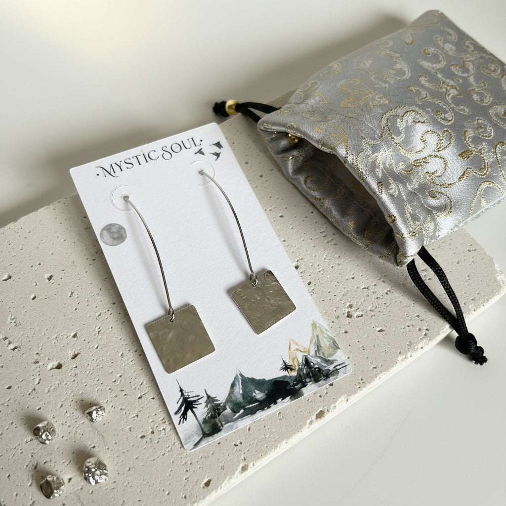 Silver plated hammered square drop earrings on a display card with a gift pouch