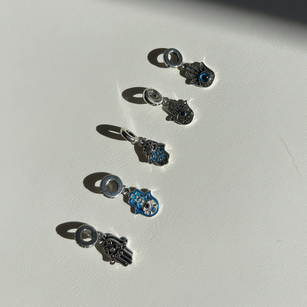 Close-up of the three sterling silver hamsa hand pendant designs side by side