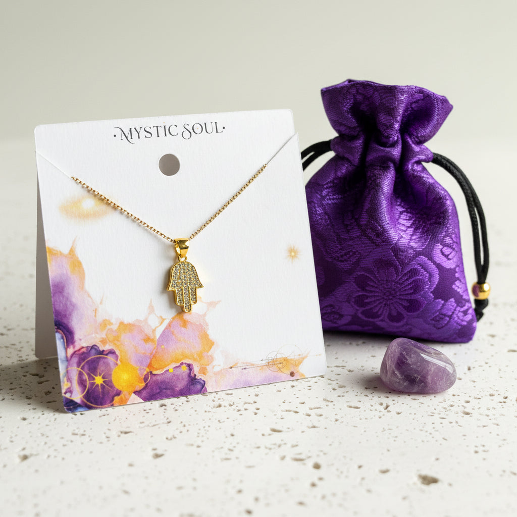 Crystal hamsa hand necklace carded with a purple pouch and amethyst