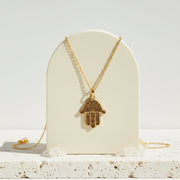 Cut-out fair trade brass hamsa hand pendant necklace from Bali — protection talisman jewelry