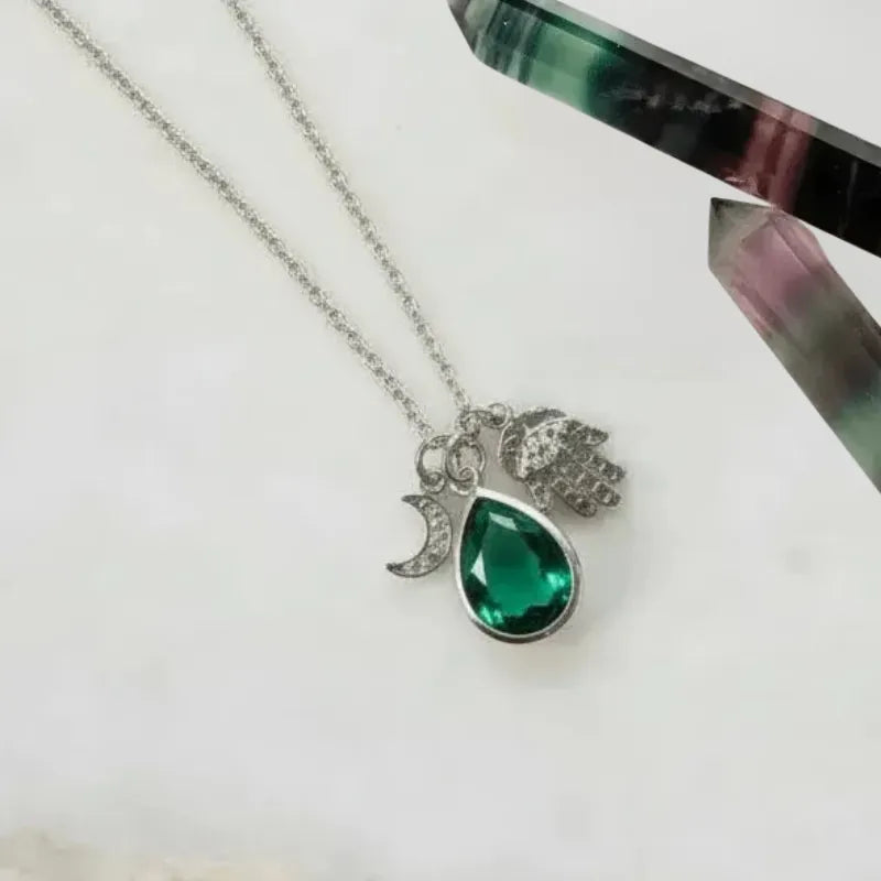 Silver plated hamsa hand and crescent moon necklace with emerald green faceted glass teardrop