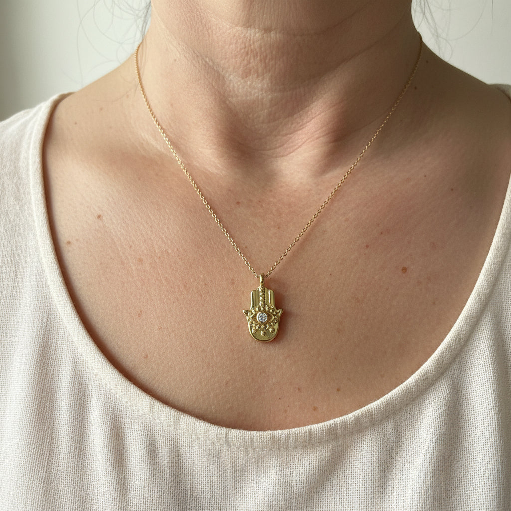 Gold plated hamsa hand pendant necklace worn at the collarbone