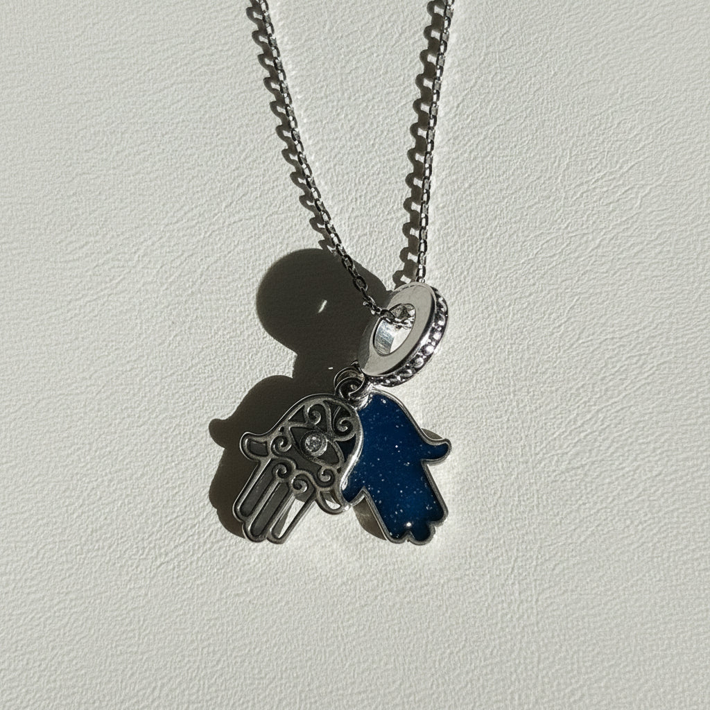 Close-up of a sterling silver hamsa hand pendant showing the blue centre and crystal detail